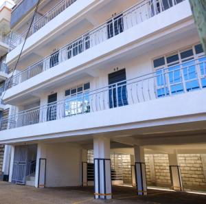 un edificio bianco con un balcone in cima di The Amber Homes a Meru