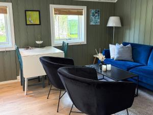 a living room with a blue couch and chairs at 4 person holiday home in OMASTRAND-By Traum in Sanddal