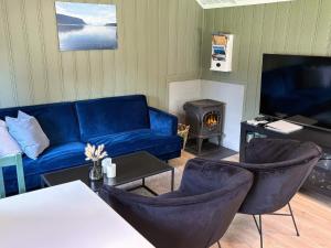 a living room with a blue couch and a fireplace at 4 person holiday home in OMASTRAND-By Traum in Sanddal