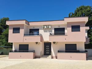 a pink building with a black door at Vila Cattleya in Donji Štoj