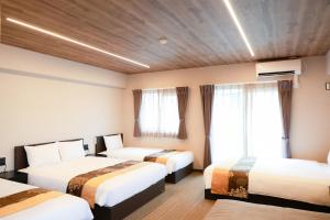 a hotel room with two beds and two windows at INNEST Hakata in Fukuoka