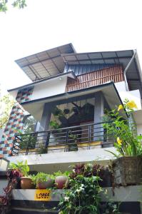 a house with a balcony with potted plants on it at Nirrvaan homestay in Varkala