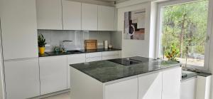 a kitchen with white cabinets and a black counter top at Ferienhaus Panoramablick Altfalter in Schwarzach bei Nabburg