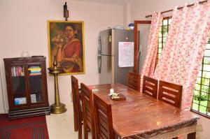 a dining room with a table and a refrigerator at Nirrvaan homestay in Varkala +26 photos
