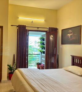 a bedroom with a bed and a sliding glass door at Nirrvaan homestay in Varkala