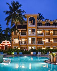 a hotel with a swimming pool in front of a building at Park Inn by Radisson Goa Candolim in Candolim