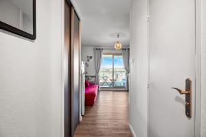 a hallway with a door and a red couch at T2 dans résidence arborée in Six-Fours-les-Plages