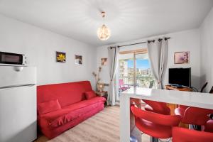 a living room with a red couch and red chairs at T2 dans résidence arborée in Six-Fours-les-Plages