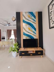 a living room with a tv and a painting on the wall at Prosperity House Southlinks in Bagam