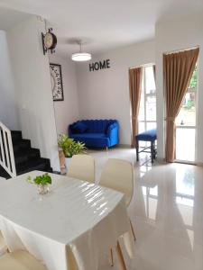 a living room with a white table and a blue couch at Prosperity House Southlinks in Bagam +7 photos