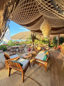 an outdoor patio with tables and chairs and an umbrella at Ankura Preá Spa & Boutique Hotel in Cruz