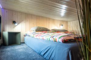 a bedroom with a bed in a wooden wall at tiny house Eisingen in Eisingen