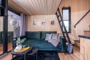 a living room with a green couch and a table at tiny house Eisingen in Eisingen