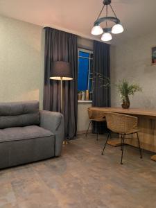 a living room with a couch and a table at Zaķēni in Āboliņi