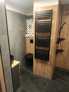 a bathroom with a wooden wall with a shelf at Apartmán Zdislava in Česká Ves