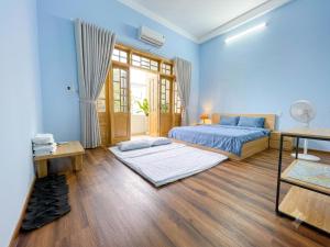 a blue bedroom with two beds and a desk at Hammer Homestay in Danang