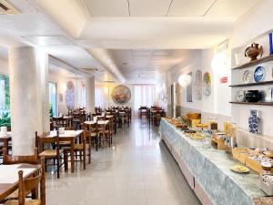 a restaurant with tables and chairs and a long counter at Hotel Canasta in Misano Adriatico +37 photos