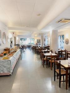 a dining room with tables and chairs and a restaurant at Hotel Canasta in Misano Adriatico