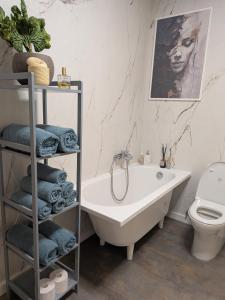 a bathroom with a white tub and a toilet at Zaķēni in Āboliņi