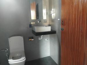 a bathroom with a white toilet and a sink at Nesan’s villa in Trincomalee +74 photos