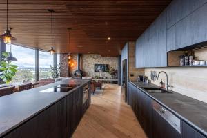 a kitchen with wooden cabinets and a large counter top at BullerRoo Luxury Chalet & Cottage Farmstay in Barwite