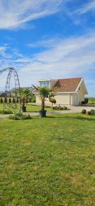 a small white house with a playground in a field at 3 ruoniai in Palanga +35 photos