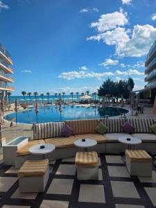 a view of a pool with a couch and tables at Sandy Bay Resort - All Inclusive Private Beach Hotel in Sveti Vlas