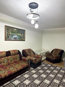 a living room with a couch and a chair at Тихий дом in Fergana