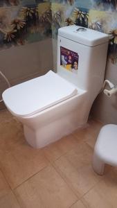 a white toilet in a bathroom with a book on it at Hotel Shepherds in Bīdar +5 photos