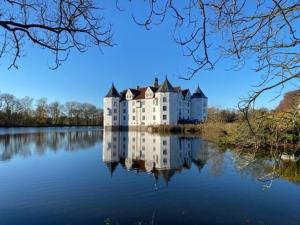 a large castle sitting on top of a lake at Ferienhaus 'Seeblick 39' in Glücksburg +17 photos