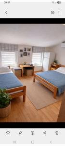 a bedroom with two beds and a table and a desk at Jakišnica Apartment in Lun