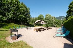 a bunch of lounge chairs and tables on a beach at Les Sources - 30 personnes in Bussang