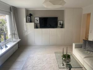 a living room with a couch and a tv at Ferienwohnung Edelweiss am Steinberg in Goslar mit Terrasse und Garage in Goslar