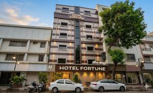 a hotel with two cars parked in front of it at Hotel Fortune in Mumbai