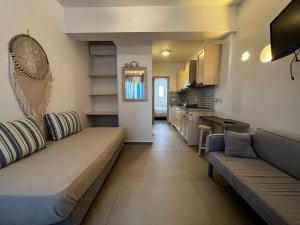 a living room with a couch and a kitchen at sun studios in Mikonos