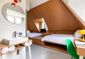 a bathroom with a bed and a sink and a mirror at Hotel BonBon & BonBon Budget in Rotterdam