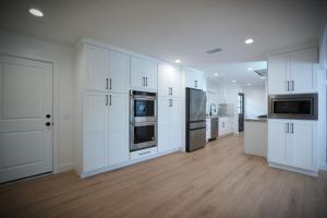 a large white kitchen with white cabinets and appliances at Awesome 5 bedroom 3 bath pool home with in-ground jacuzzi in Orange