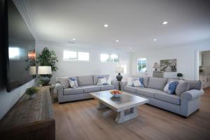 a living room with two couches and a coffee table at Awesome 5 bedroom 3 bath pool home with in-ground jacuzzi in Orange