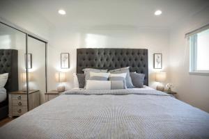 a bedroom with a large bed with a large headboard at Awesome 5 bedroom 3 bath pool home with in-ground jacuzzi in Orange +34 photos