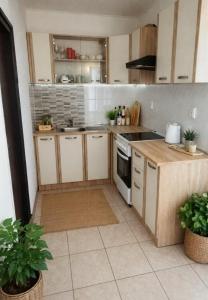 a kitchen with white cabinets and a stove top oven at Jakišnica Apartment in Lun