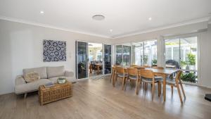 a living room with a table and chairs and a couch at Blissful Birdsong Escape in Banksia Beach