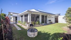 a white house with a lawn in front of it at Blissful Birdsong Escape in Banksia Beach