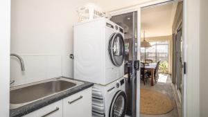 a kitchen with a washer and dryer next to a sink at Blissful Birdsong Escape in Banksia Beach +13 photos
