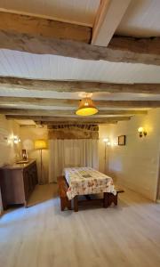 a bedroom with a bed and a table in a room at La maison de Coq-licot ! in Salignac Eyvigues