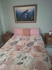 a bedroom with a bed with a floral bedspread at Over the Rainbow Guest House in Hibberdene