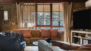 a living room with a couch and a large window at Cedar and Stone - Daylesford Region in Glenlyon