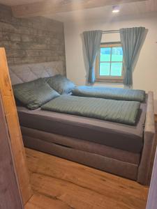 a bed in a small room with a window at Ferienwohnung Loifried in Abtenau