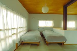 two beds in a room with a window at 浬-kairi-1852 in Choshi