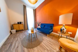 a living room with a blue couch and a table at Inderooms Carloforte in Carloforte