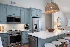 a kitchen with blue cabinets and a kitchen island with stools at Family Friendly 4BR Oxford Home Near The Square in Oxford